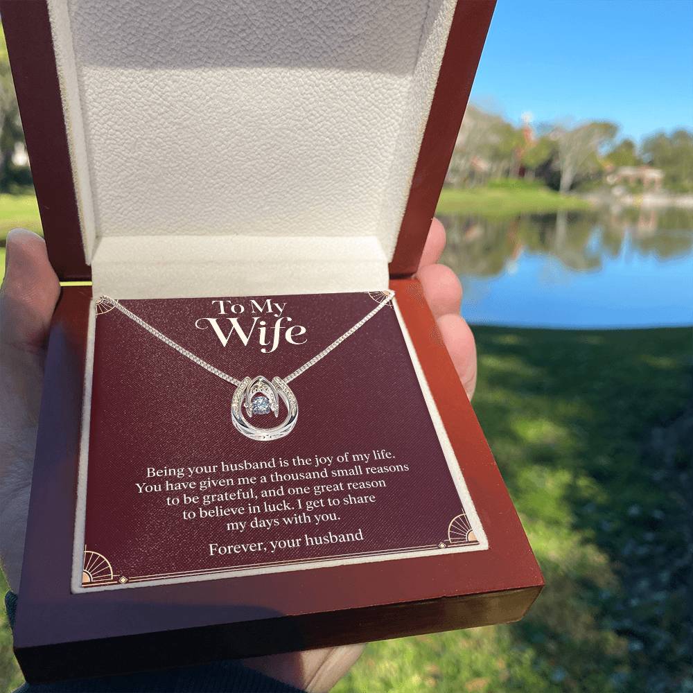 Lucky In Love necklace and Wife message card in luxury box held outdoors | Hensley London