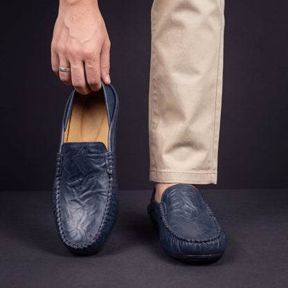 Men's Slip-On Loafers with Apron Stitching in Navy – worn and held front view | Hensley London