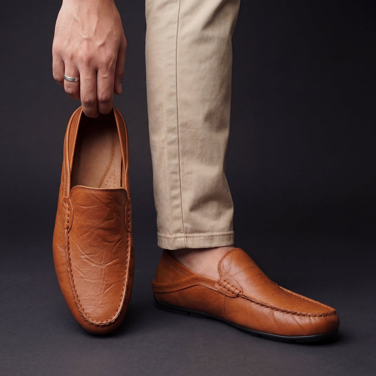 Men's Slip-On Loafers with Apron Stitching in Chestnut – worn and held front view | Hensley London