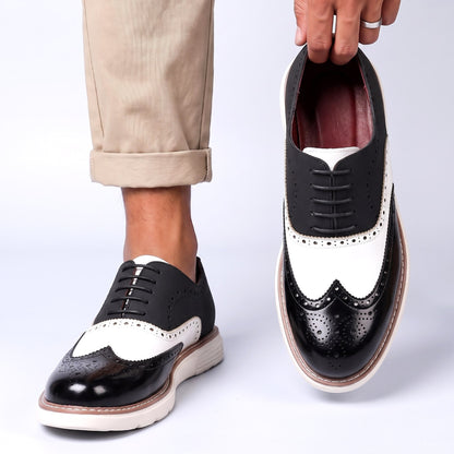 Men's Faux Leather Two-Tone Wingtip Brogue Shoes in Black – worn and held front view | Hensley London