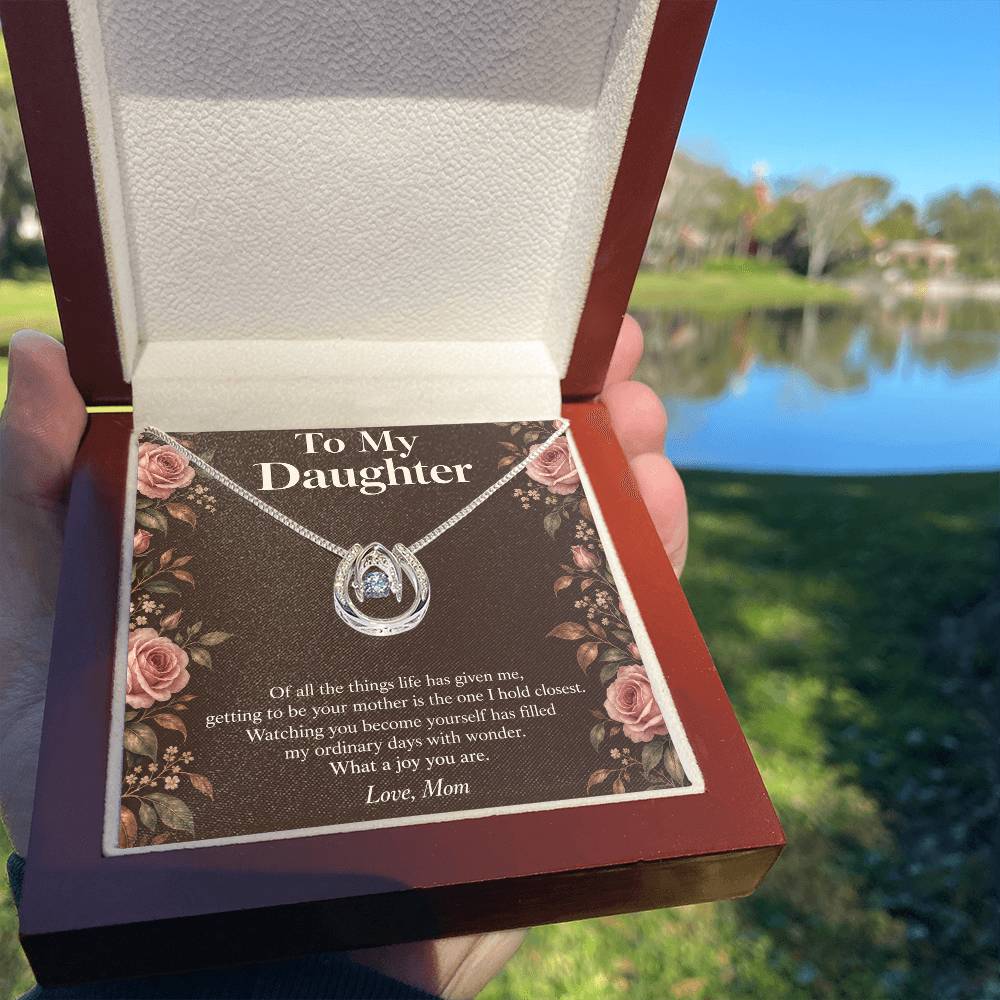 Lucky In Love necklace and Daughter message card in luxury box held outdoors | Hensley London