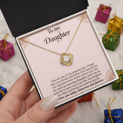 Love Knot necklace with Blush Art Deco daughter message card – yellow gold finish necklace in Standard Box held in hand | Hensley London
