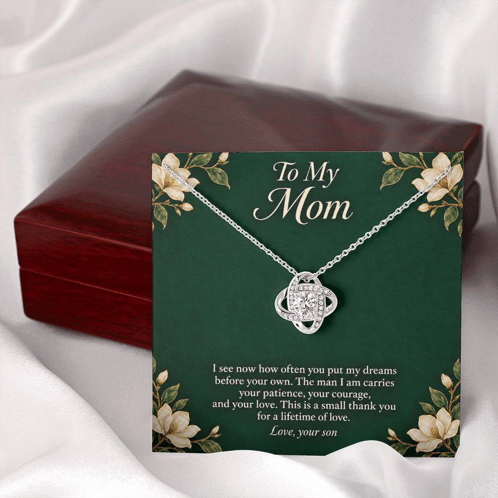 White-gold Love Knot necklace and emerald Mom message card beside closed luxury box | Hensley London