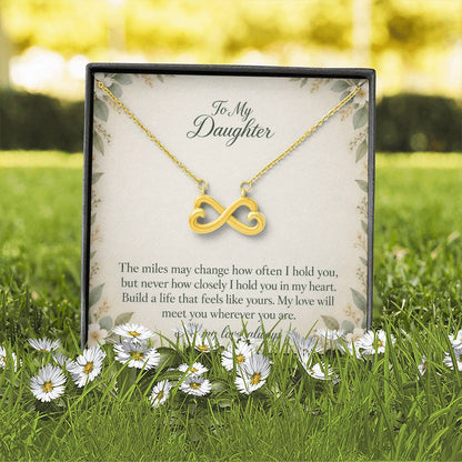 Yellow-gold Endless Love infinity necklace and Daughter message card in standard box outdoors | Hensley London