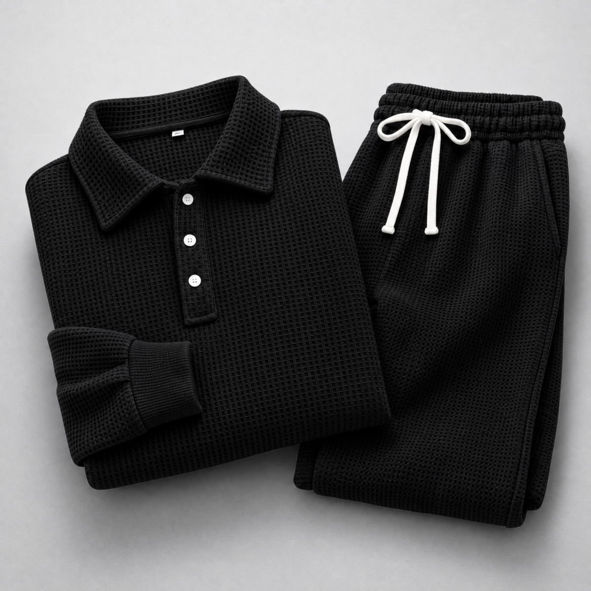 Men's Waffle-Knit Polo and Drawstring Trouser Set in Black – folded detail view | Hensley London