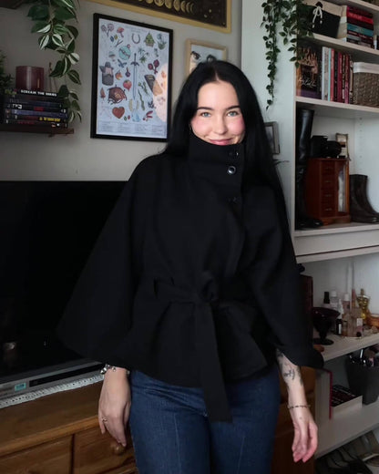 Women's High-Neck Belted Cape Jacket in Black - lifestyle view | Hensley London