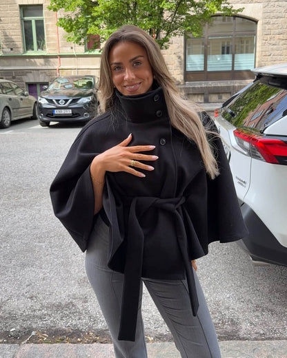 Women's High-Neck Belted Cape Jacket in Black - lifestyle view | Hensley London