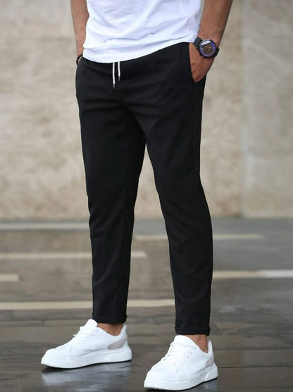 Men's Drawstring Tapered Trousers with Elasticated Waist in Black – front view on model | Hensley London