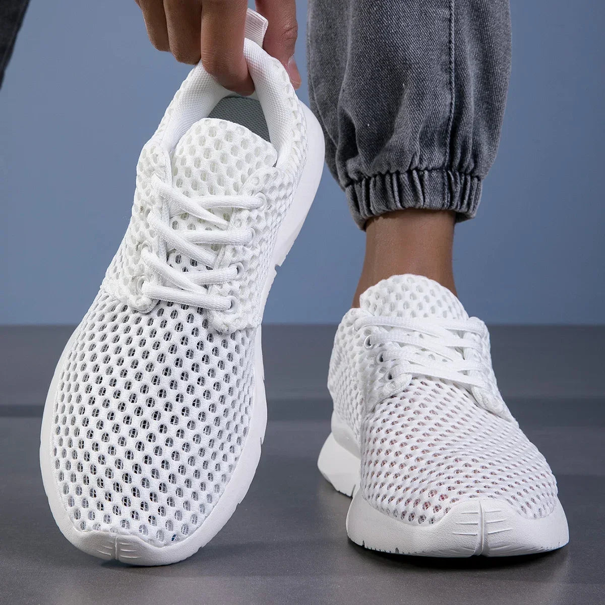 Men's Mesh Lace-Up Trainers in White – handheld and on-foot view | Hensley London