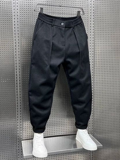 Men's Pleated Tapered Trousers with Belt Loops in Black – angled front view | Hensley London