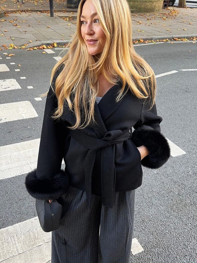Women's Belted Shawl-Collar Coat with Textured Cuffs in Black – side outdoor worn view | Hensley London