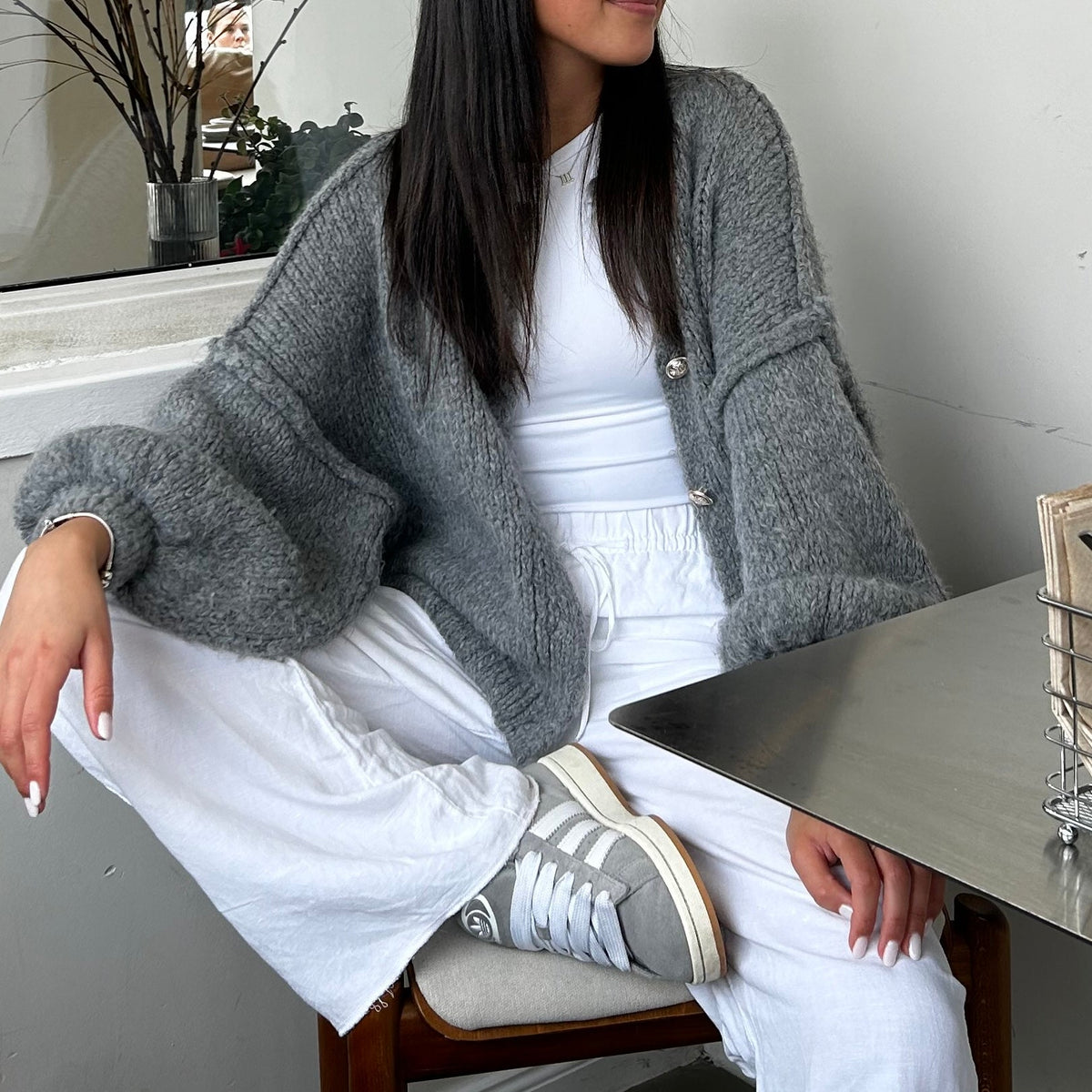 Women's Oversized Knit Cardigan – Gold-Tone Buttons in Grey – seated styling view | Hensley London